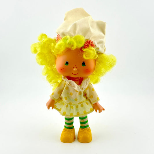 Toy figure with yellow hair and outfit on a white background