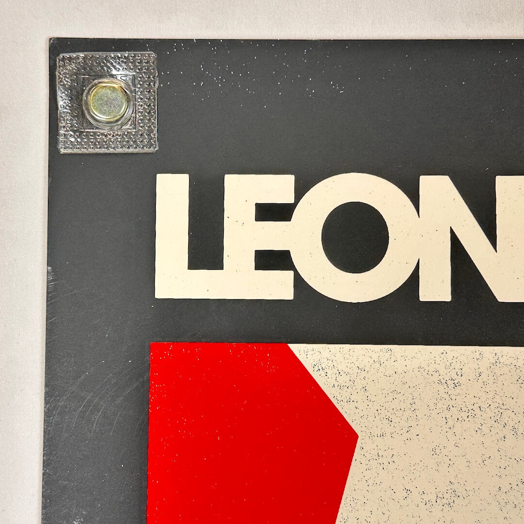 Close-up of a sign with 'LEON' in white letters on a black background.