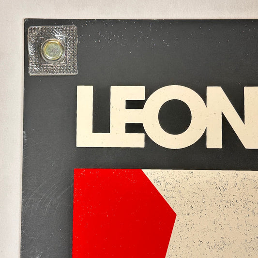 Close-up of a sign with 'LEON' in white letters on a black background.