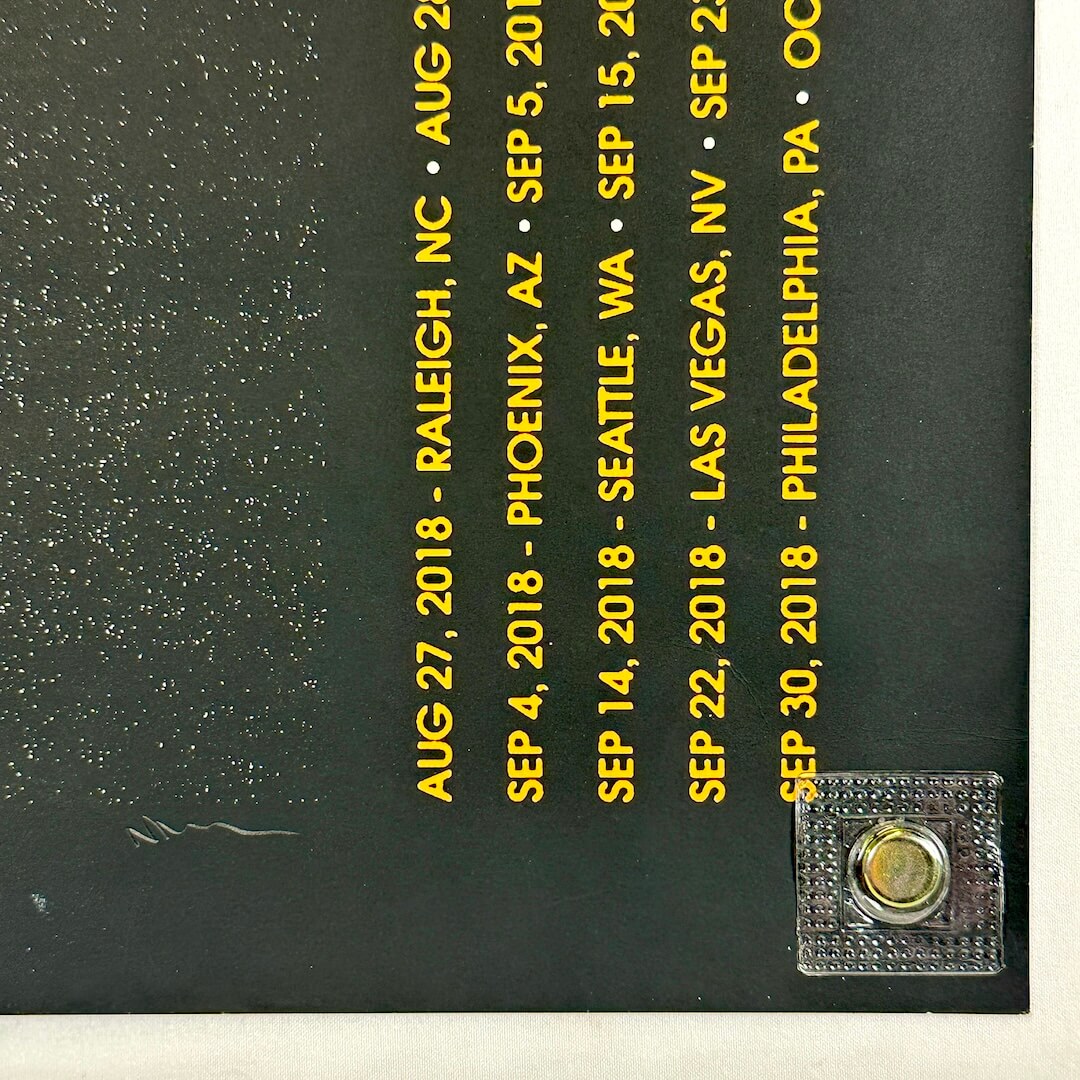 Black surface with yellow text listing dates and locations, and magnet on a white background.