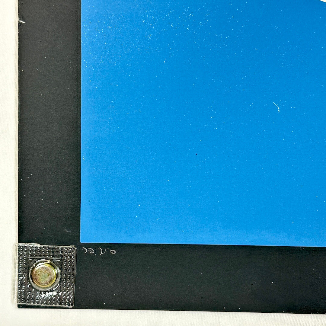 Close-up of a corner where black and blue materials meet with a metallic fastener.