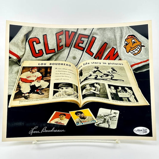 Baseball memorabilia featuring a Cleveland jersey, Lou Boudreau's life story book, and trading cards on a black background.