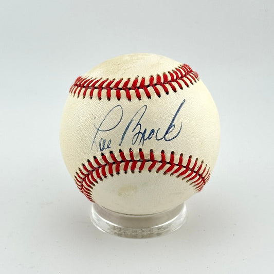 Baseball with red stitching and a signature on a white background