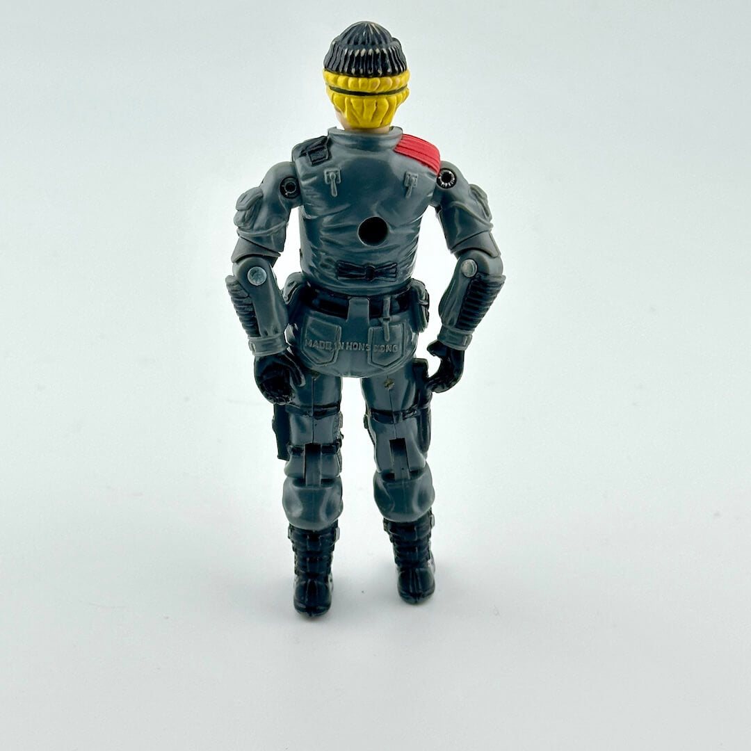Toy figure in a gray suit with a red shoulder pad on a white background