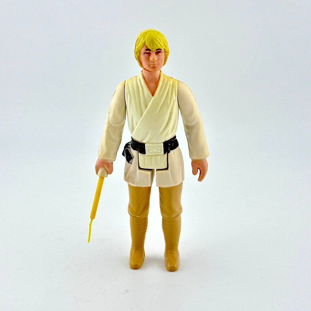 Action figure in a beige outfit with a yellow lightsaber on a white background