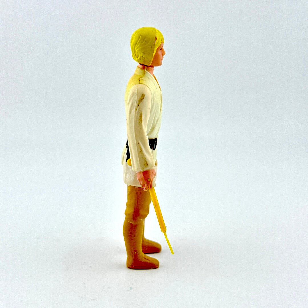 Toy figure in a yellow raincoat and boots holding a yellow umbrella on a white background