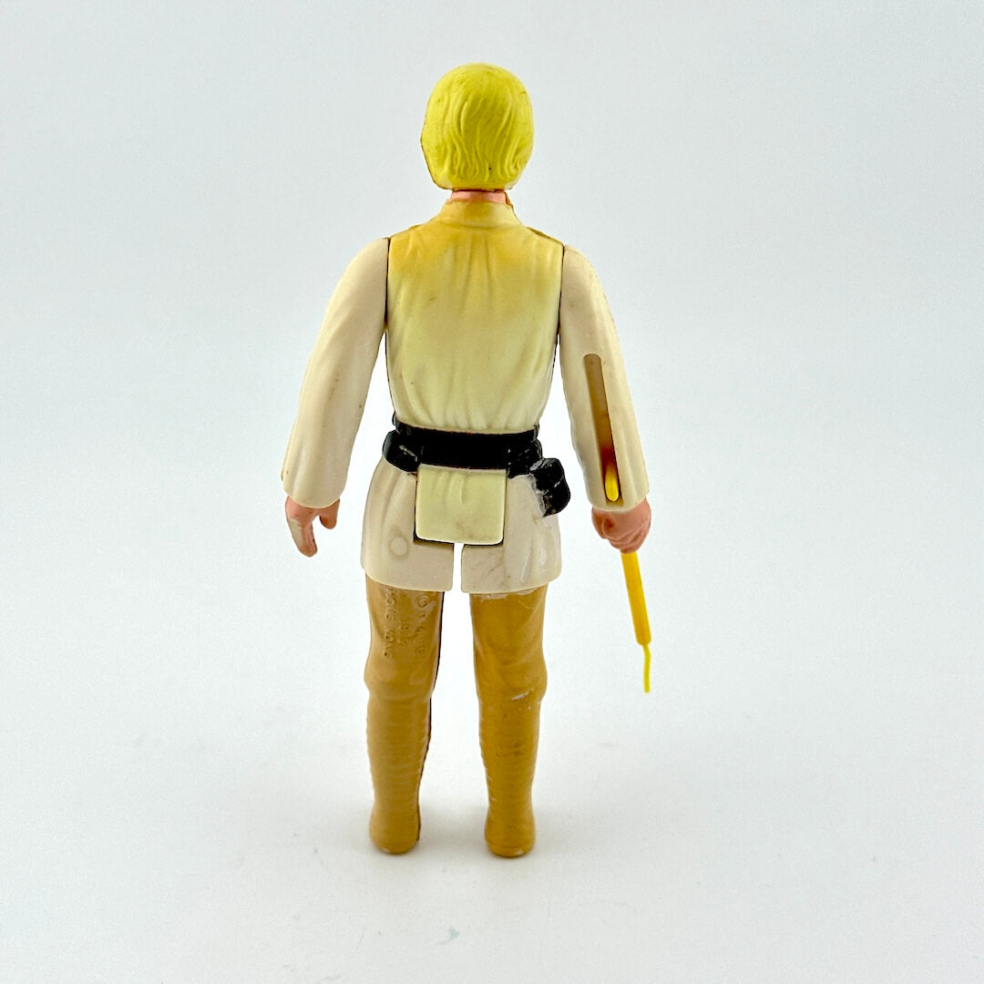 Action figure in a yellow and beige outfit holding a lightsaber on a white background