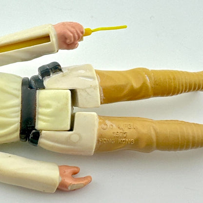 Close-up of a toy figure's arm and hand with a white background