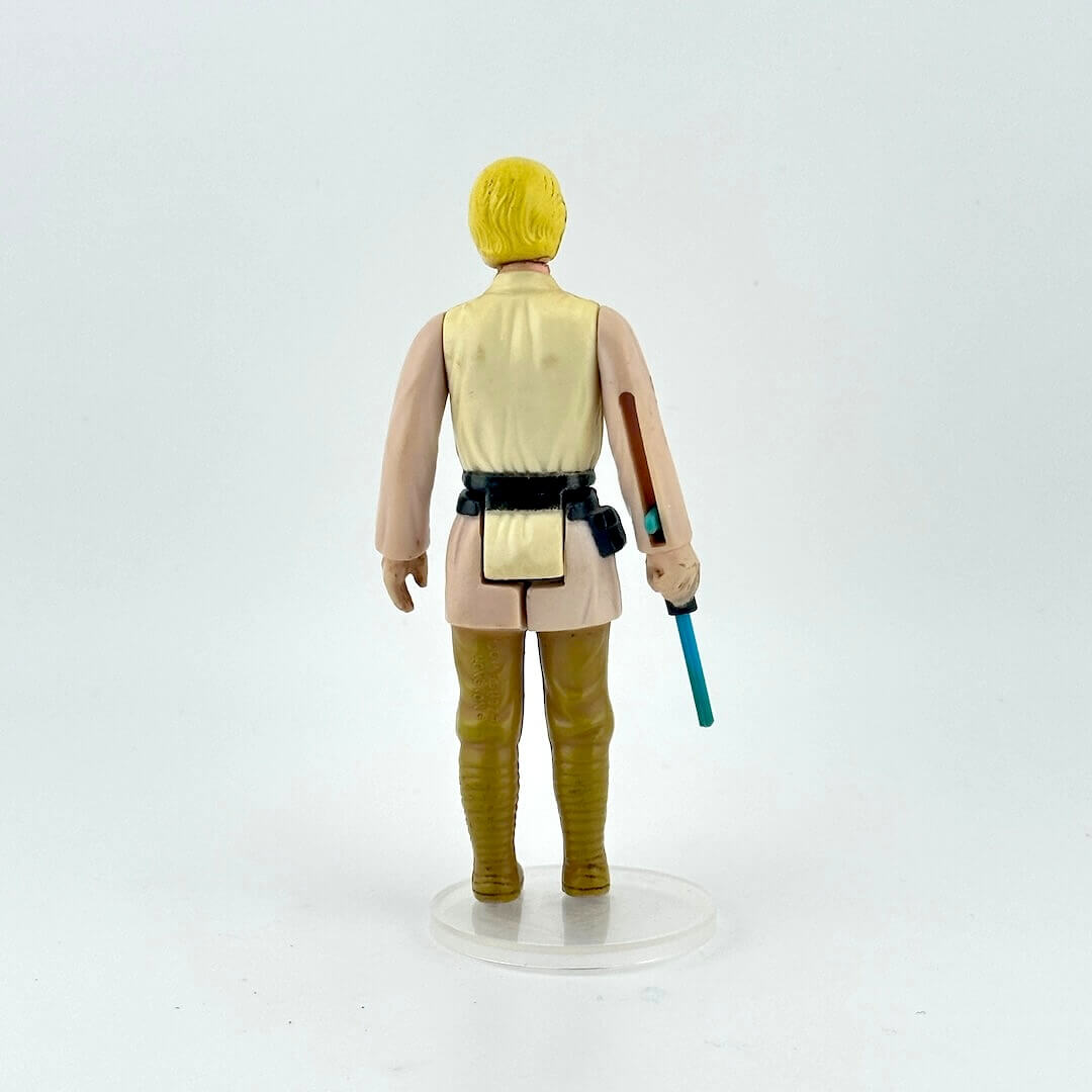 Action figure with yellow hair and a blue lightsaber on a white background