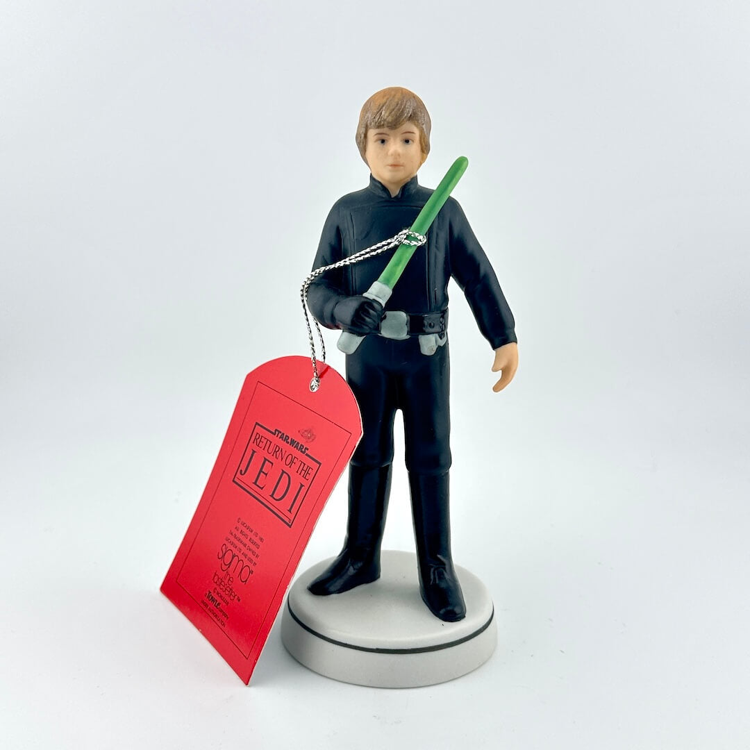 Star Wars figurine with a green lightsaber and red tag on a white background