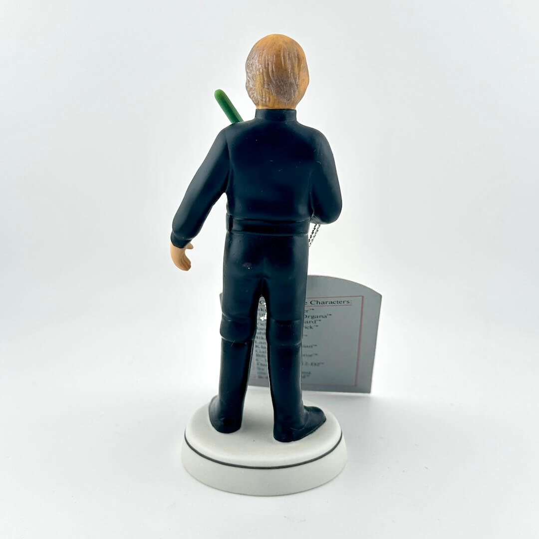 Star Wars figurine with a green lightsaber and red tag on a white background