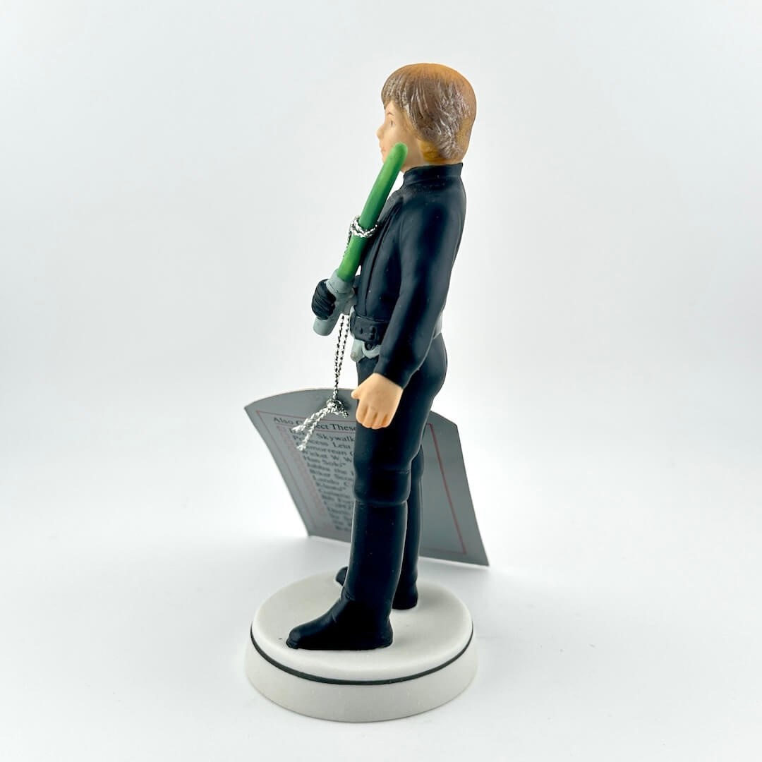 Star Wars figurine with a green lightsaber and red tag on a white background