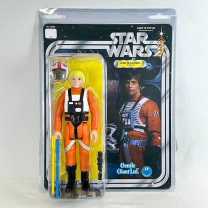 Jumbo action figure of Luke Skywalker in his orange X-wing pilot jumpsuit, packaged in a clear plastic blister pack.