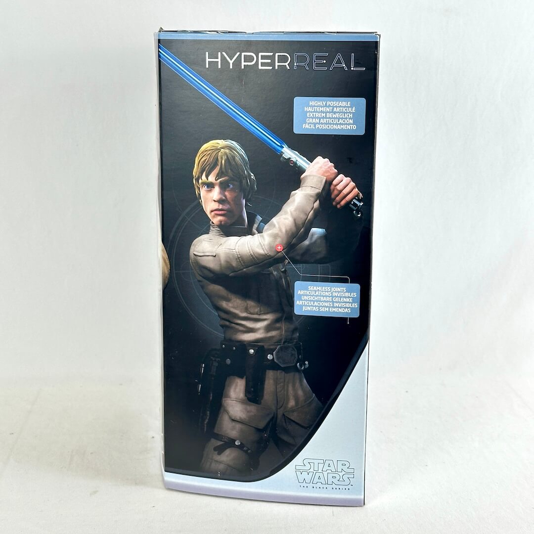 Luke Skywalker toy packaging, featuring a printed illustration of Luke with a glowing blue lightsaber on a black and silver box.
