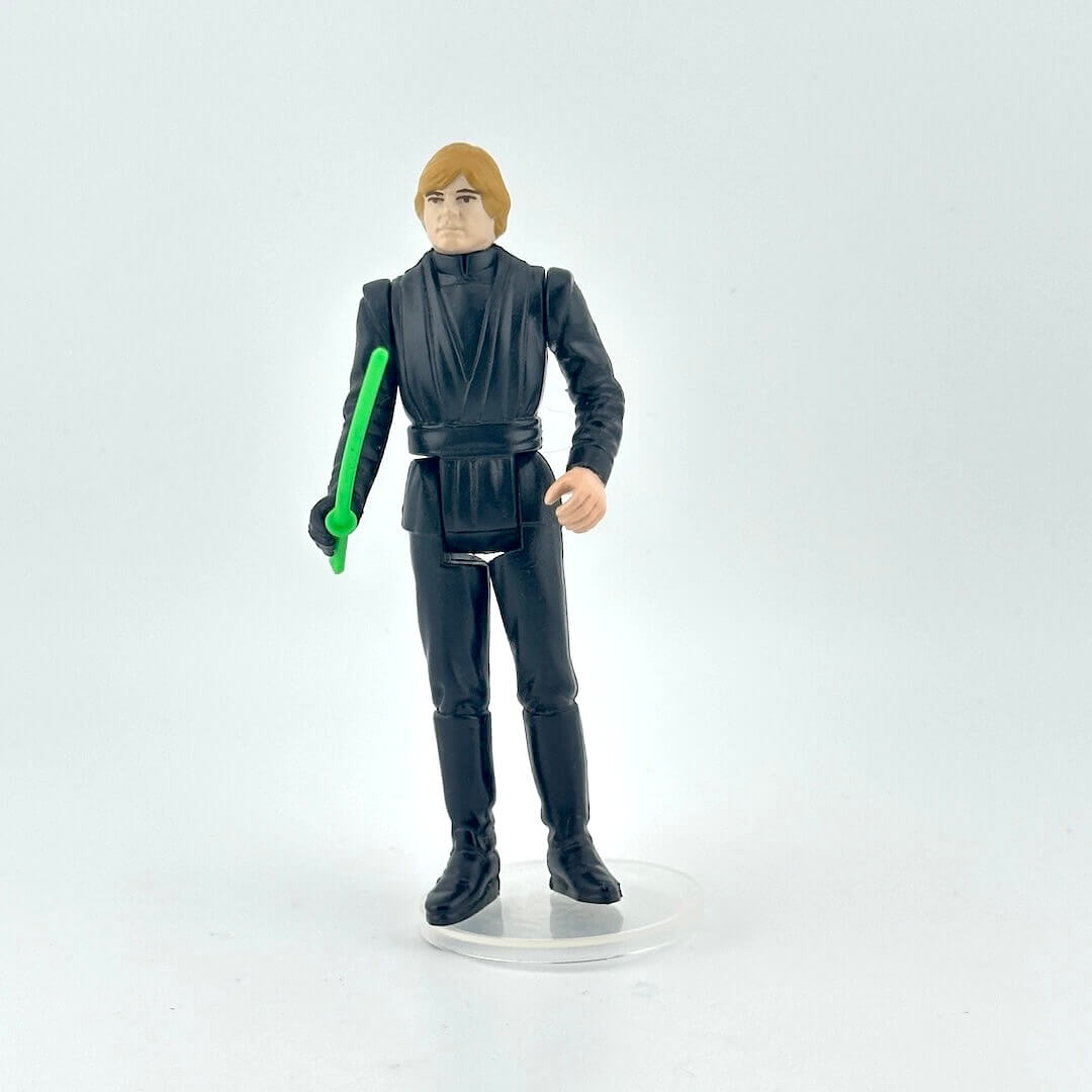 Action figure in black outfit with green lightsaber on a white background