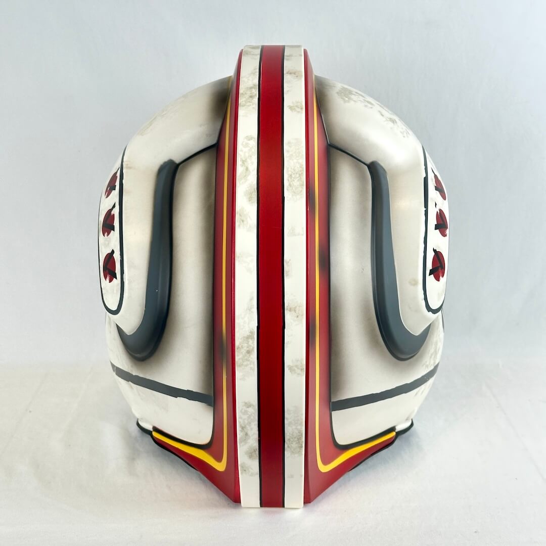 Back view of Luke Skywalker replica helmet with red, black, and yellow accents. 