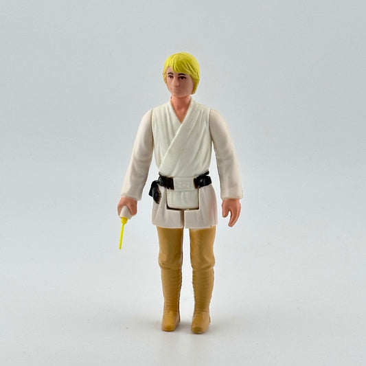 White male action figure with yellow hair in white shirt, black belt & tan pants, yellow lightsaber emerging from right hand.