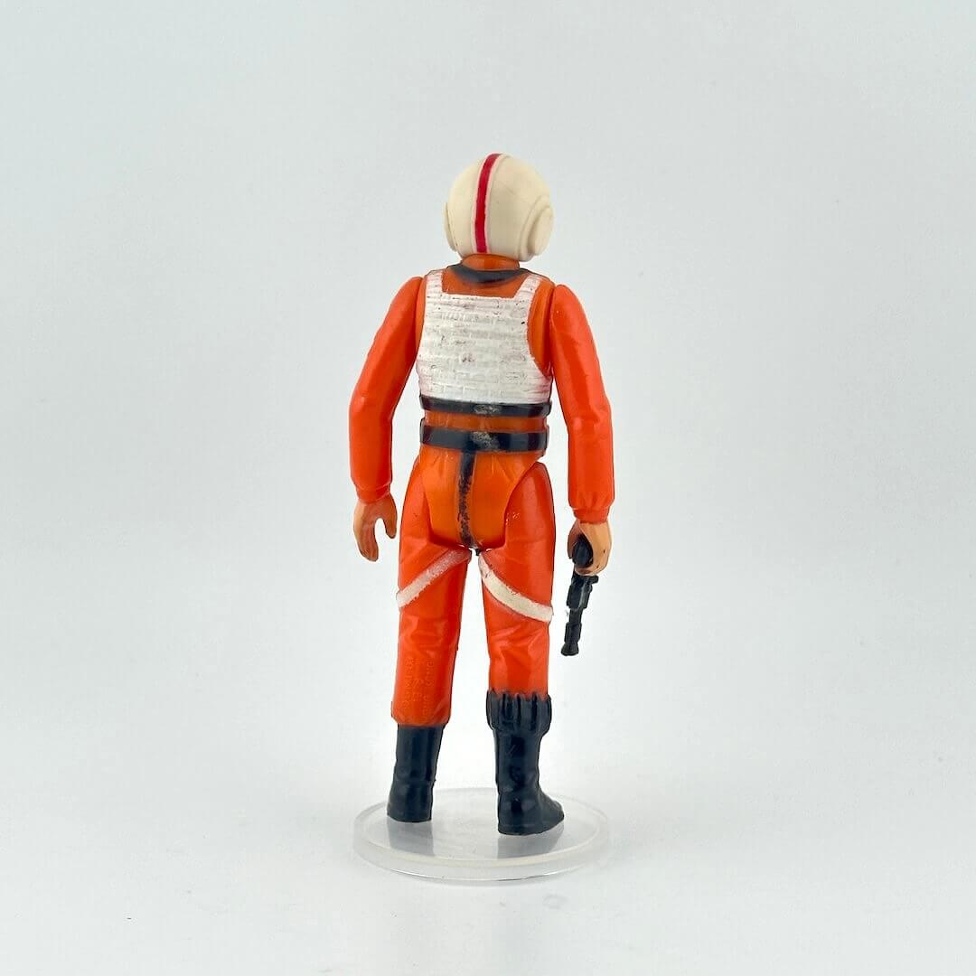Action figure in orange and black outfit with helmet on a white background