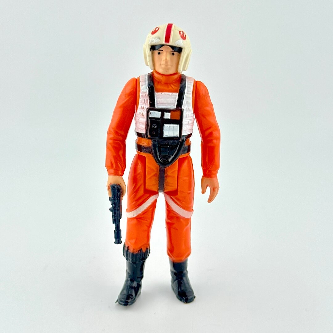 Action figure in orange jumpsuit with helmet on a light gray background