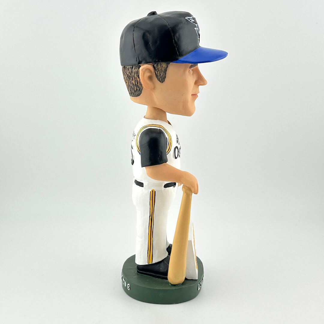 Bobblehead of a baseball player in a black and white uniform with a blue cap, holding a bat.