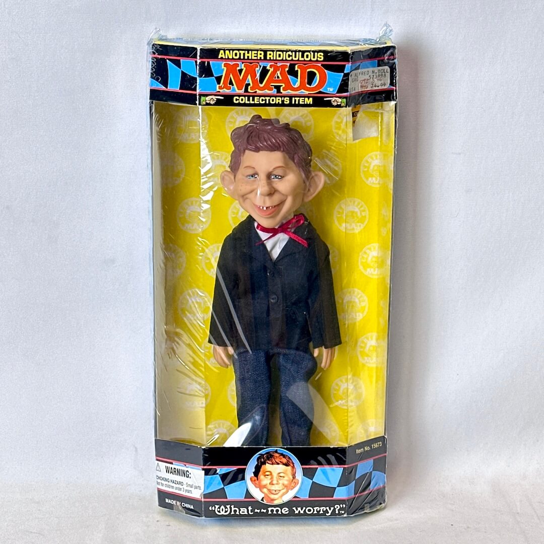 Toy figure in packaging with 'MAD' branding on a white background