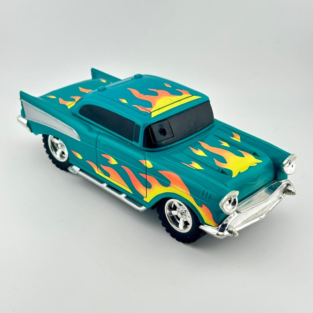 A teal toy hot rod car with yellow and orange flame decals, chrome bumpers and wheels.