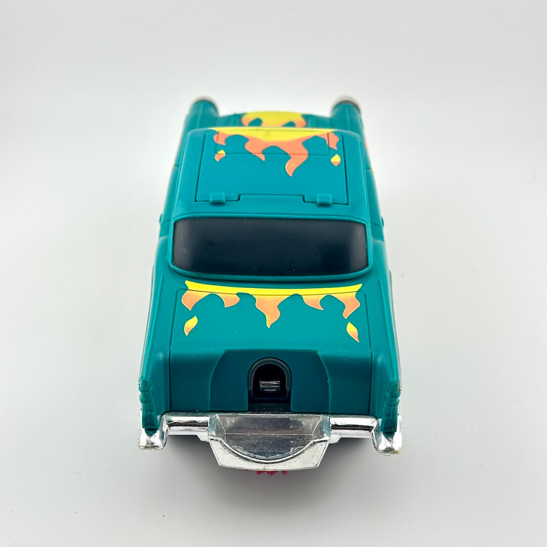 A teal toy car viewed from the rear, featuring yellow and orange flame decals on the trunk and roof, with a silver chrome bumper and bumper bar.