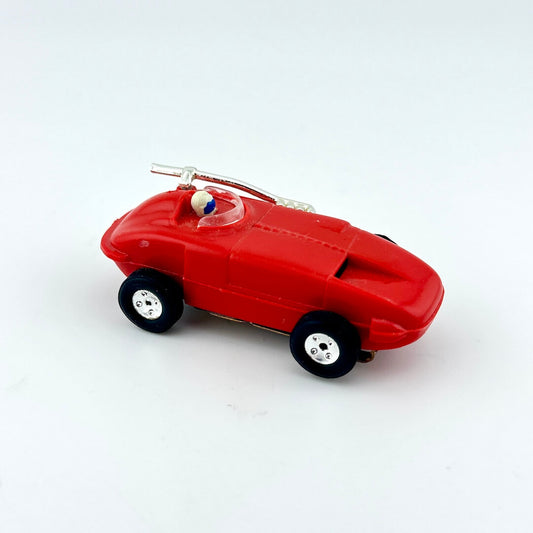 Red toy car with a small figure on a white background