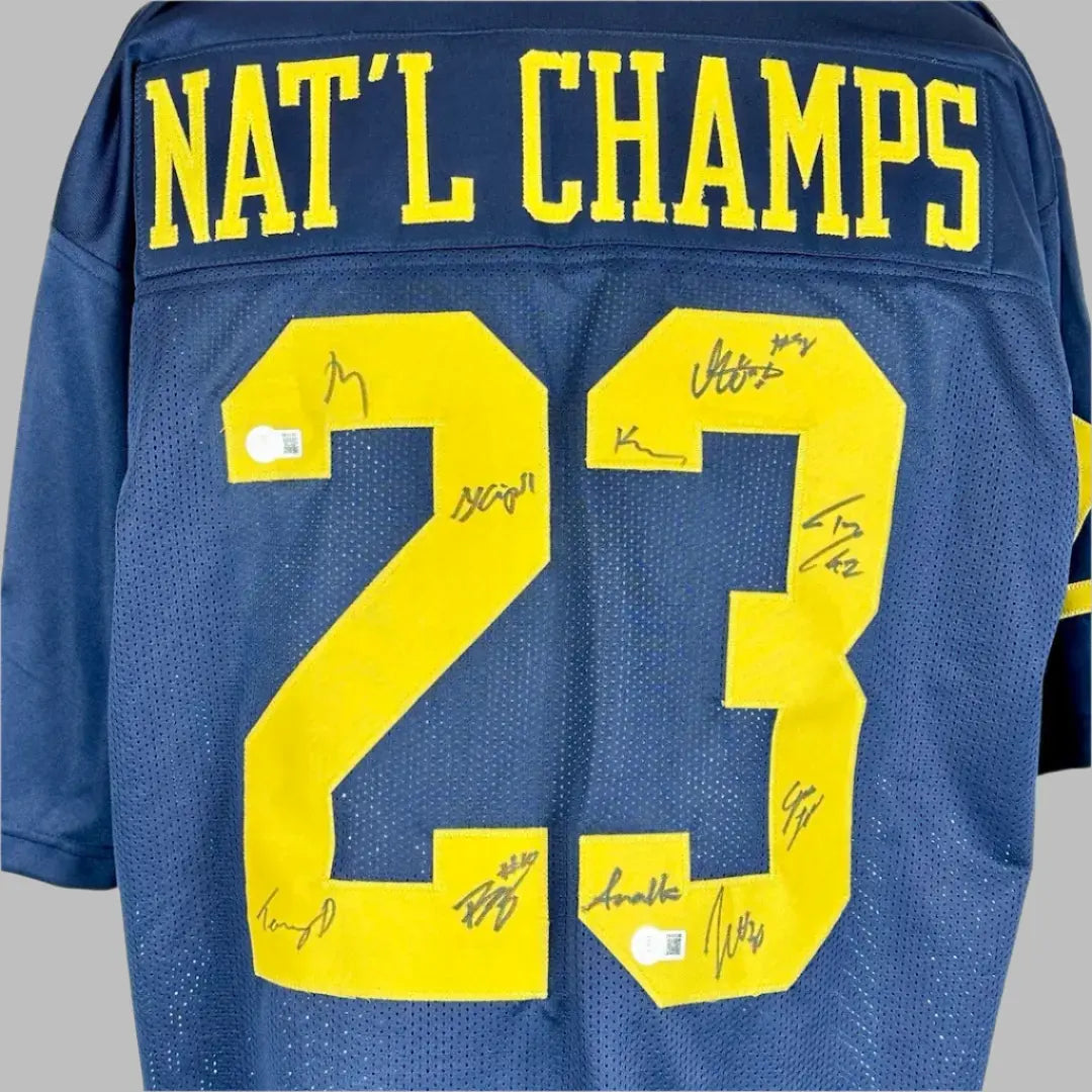 Closer image of autographs on stitched on numbers on reverse side of navy jersey.