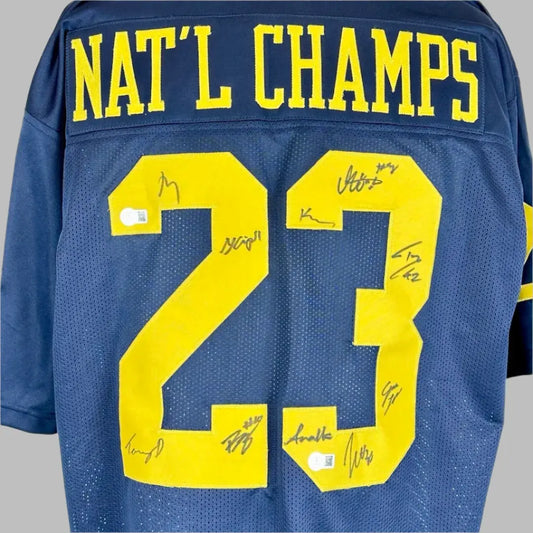 Closer image of autographs on stitched on numbers on reverse side of navy jersey.