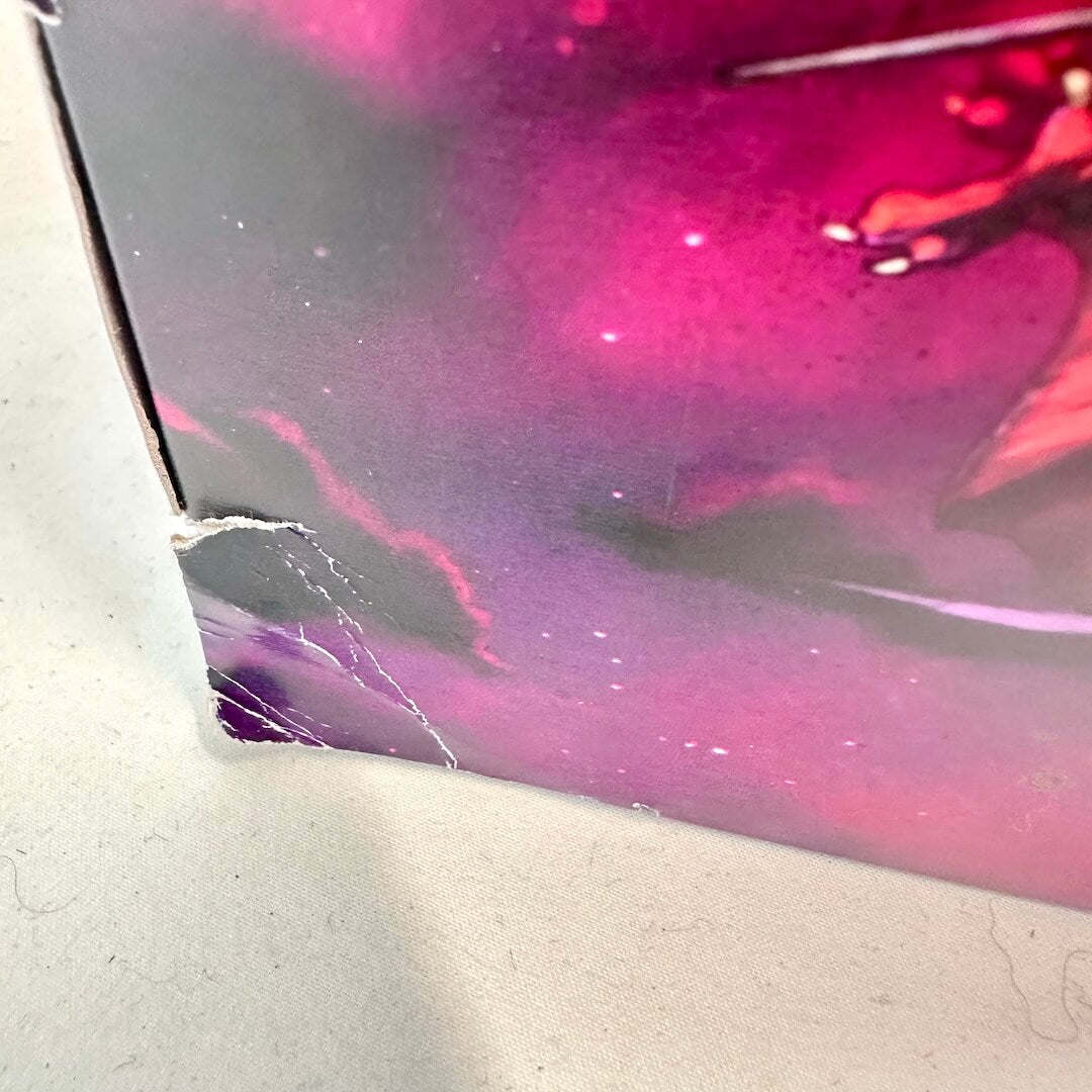 Corner of box with rip and dent. 