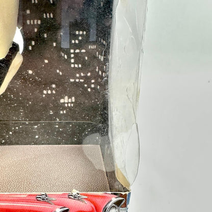 Close up of corner of plastic window on front of box showing some damage. 