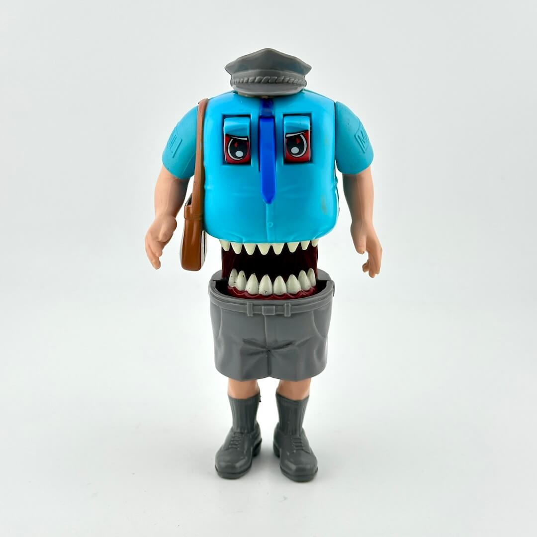 Toy figure with a blue shirt, gray pants, and a brown bag on a white background