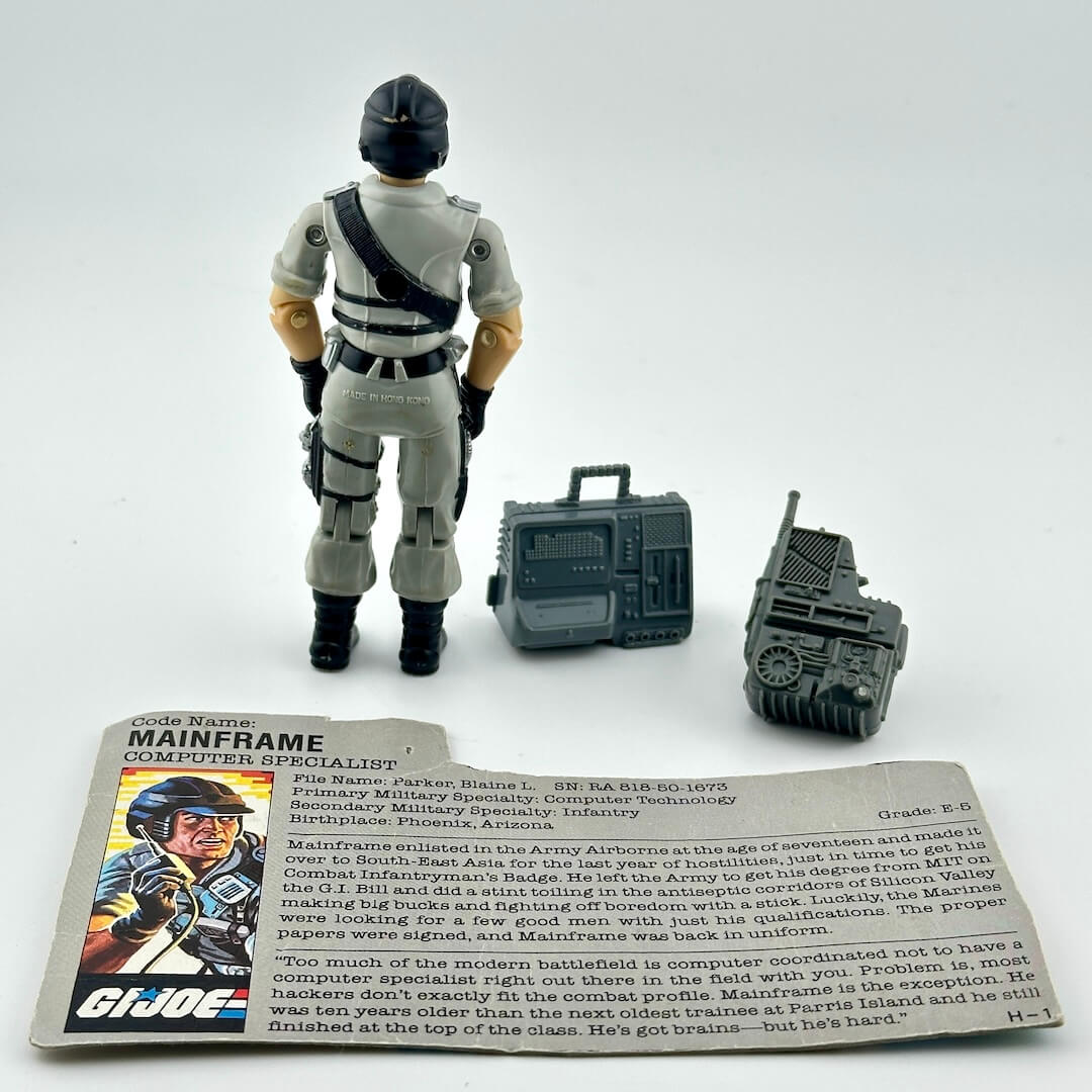 GI Joe action figure with accessories and character card against white background. 