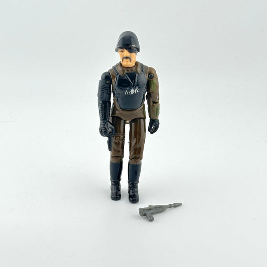 Action figure in military-style outfit with helmet and weapon on a white background