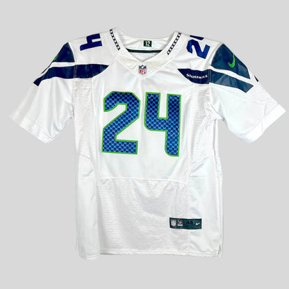 A white Seattle Seahawks football jersey with the number 24 on the front, featuring blue and green patterned numbers.