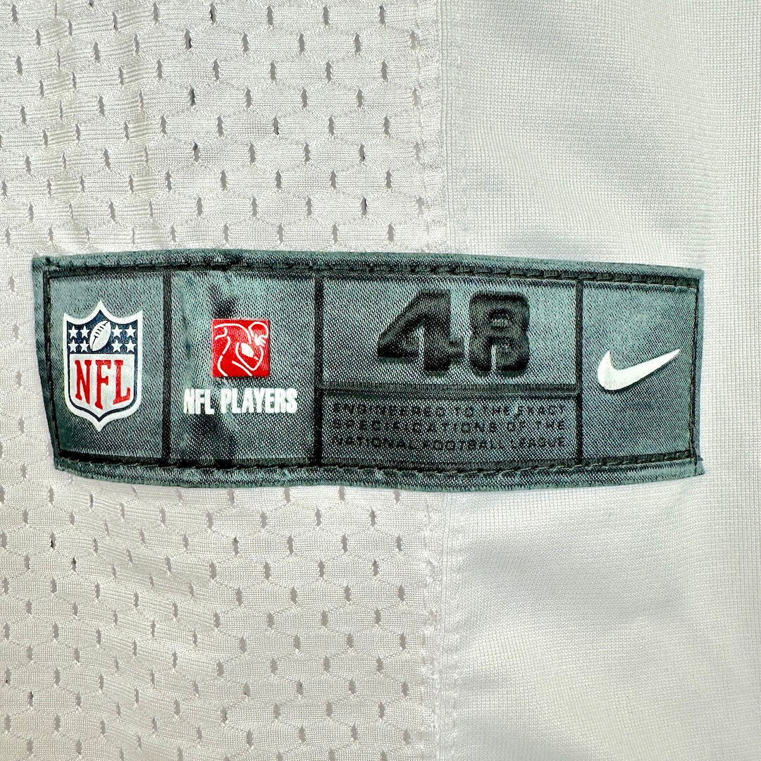 Close-up of a white mesh sports jersey with a dark gray stitched label showing the NFL shield.