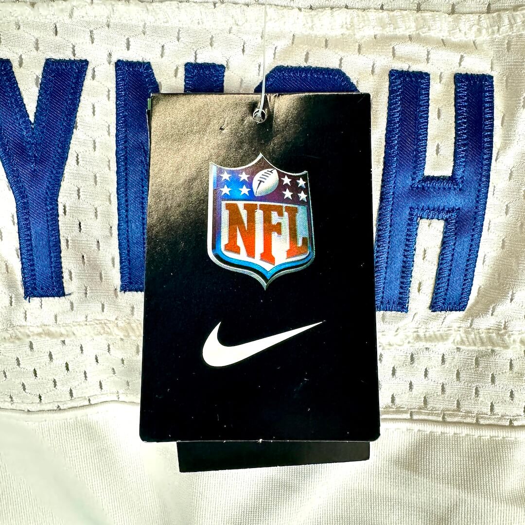 A close-up of a black hangtag with the NFL shield logo and a white Nike swoosh.
