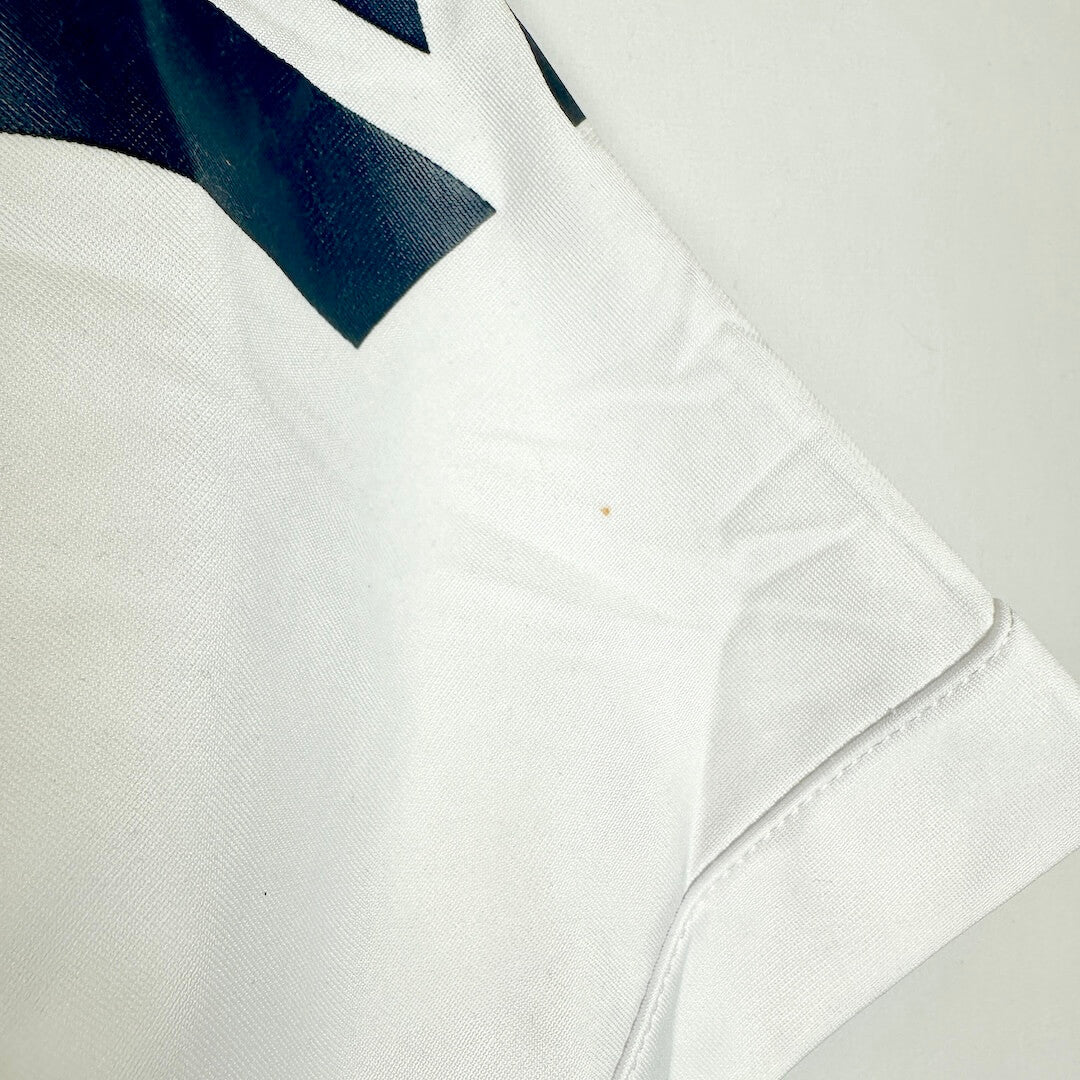 Close-up of a white fabric jersey with spot on shoulder. 