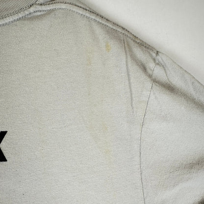Close-up of a light gray or off-white fabric surface with visible staining or discoloration.