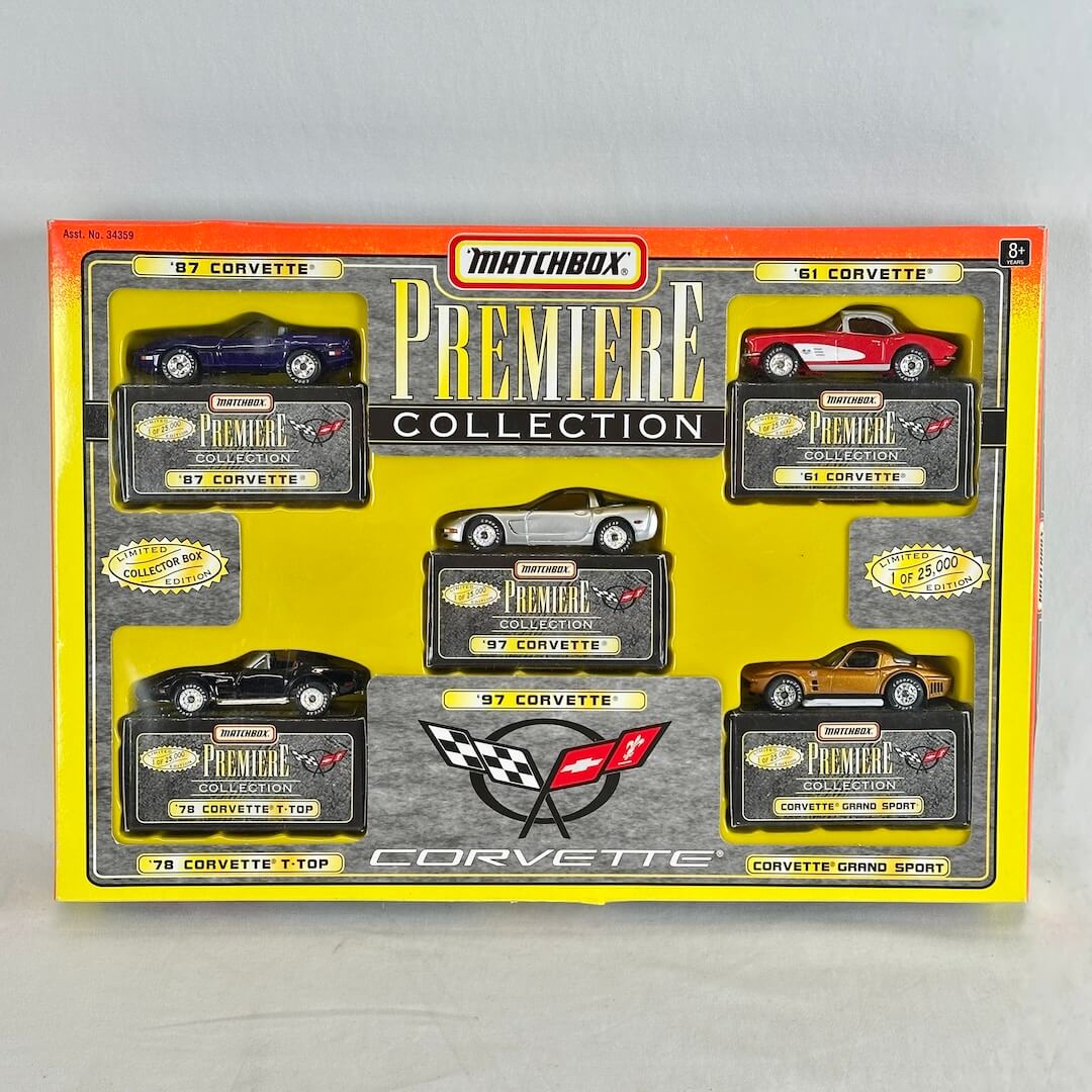 Matchbox Premiere Collection Corvette toy cars in their original yellow and orange retail box, featuring five different Corvette models.