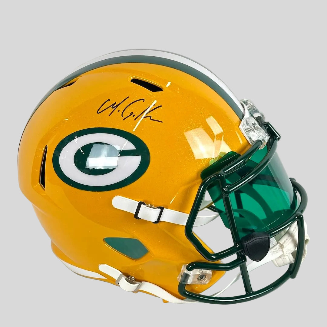 A Green Bay Packers full-face football helmet in bright yellow, signed in black ink, with a dark green visor and faceguard.
