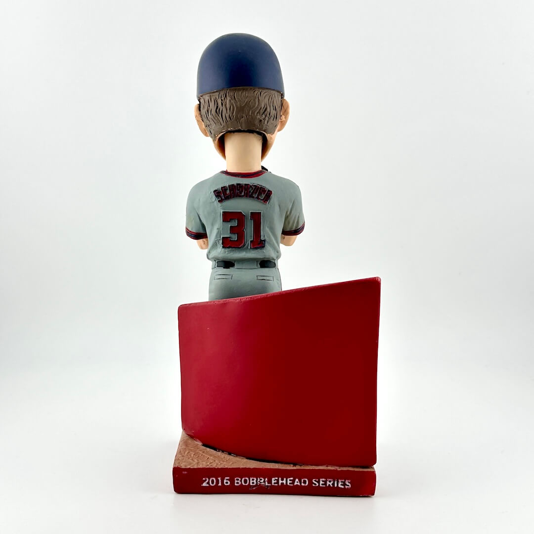 Baseball bobblehead figure with a red base on a white background