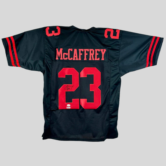 Black sports jersey with red lettering and numbers on a gray background