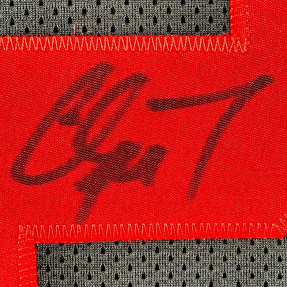 Close-up of a red fabric patch with black marker signature on a black jersey background