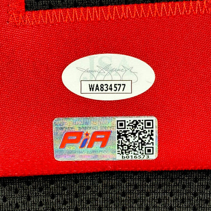Close-up of a red fabric surface with authentication sticker and QR code on black jersey.