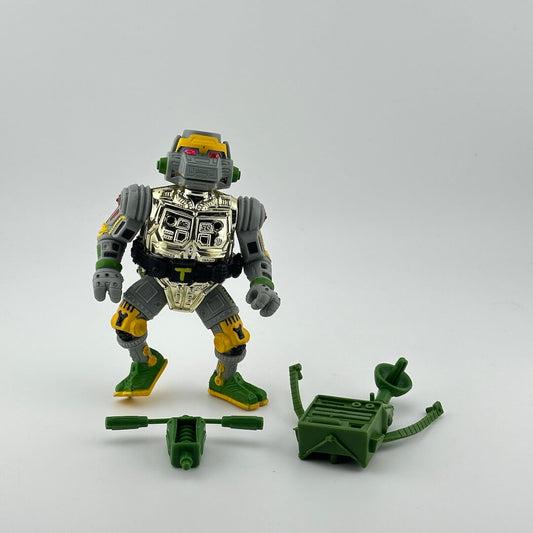Grey cyborg turtle with shiny silver chest, green & yellow details, pictured with green accessories. 