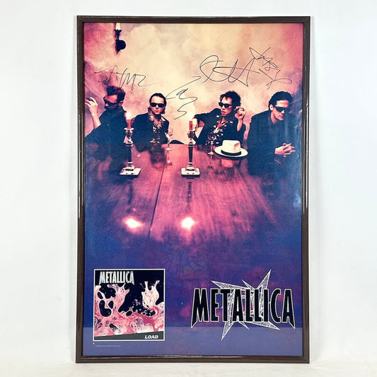 Framed poster of Metallica with autographs on a white wall
