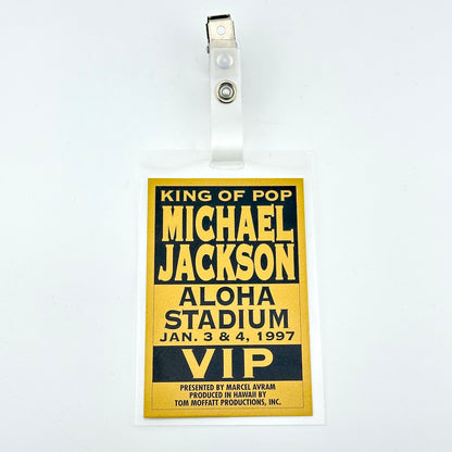 Laminated card with gold background and black text describing event details and alligator clip on plastic loop. 
