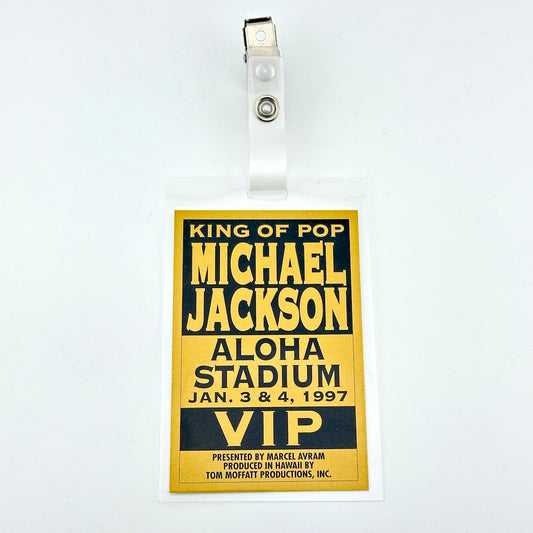 Laminated card with gold background and black text describing event details and alligator clip on plastic loop. 